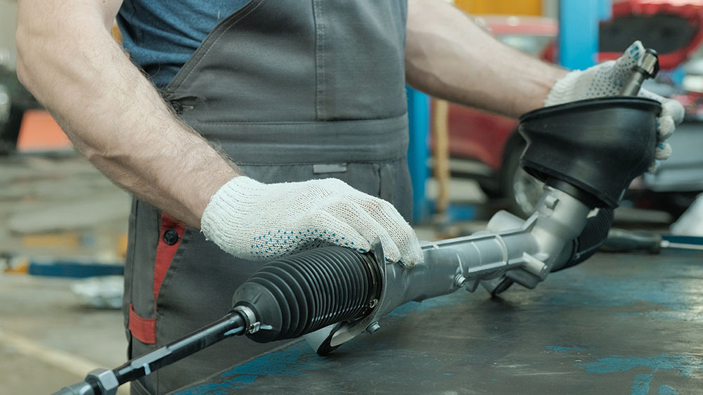 In the hands of an auto mechanic, a steering rack for a passenge